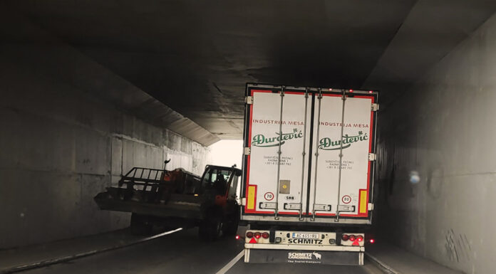 Mini bager vozi po pešačkom delu podvožnjaka Bager vozi po trotoaru